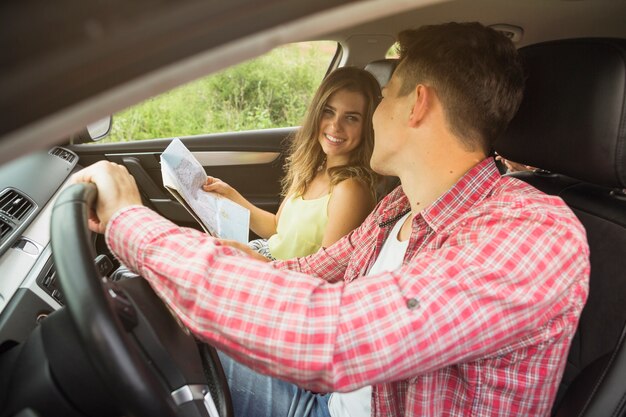 Primer plano de una pareja joven disfrutando de viajar en coche