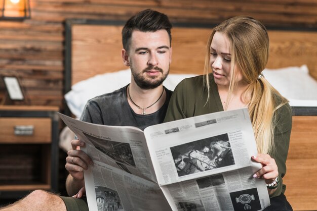 Primer plano de una pareja mirando el periódico