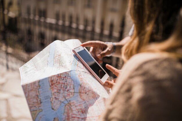 Primer plano de pareja mirando teléfono celular y mapa