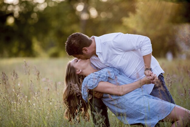 Primer plano de una pareja romántica besándose en un campo de hierba