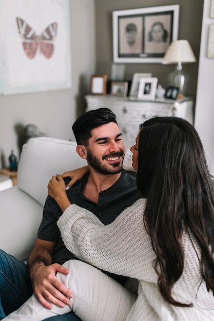 Primer plano de la pareja romántica sentado en el sofá en casa