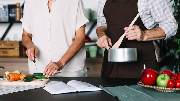 Foto gratuita primer plano de pareja senior preparando la comida en la cocina