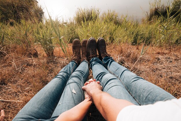 Primer plano de pareja sentada junto al lago