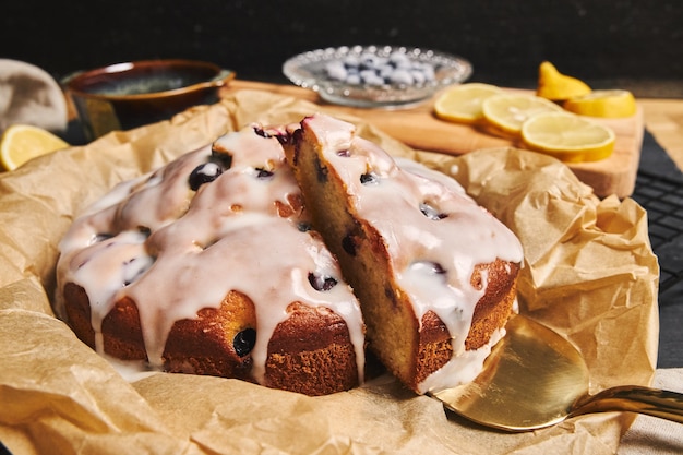 Primer plano de un pastel de cerezas con crema e ingredientes en el lado negro