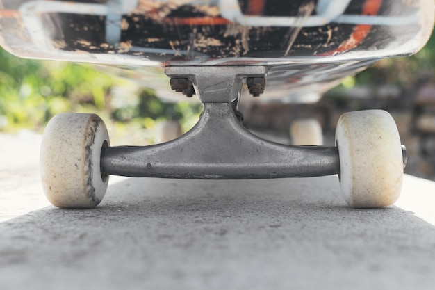 Primer plano de una patineta en el suelo bajo la luz del sol