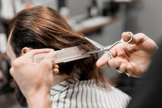 Primer plano, de, un, peluquero, mano, con, peine, corte, hombre, pelo, con, tijeras