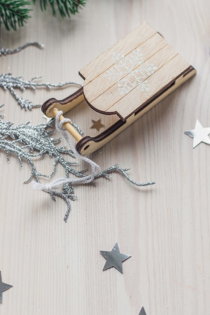 Primer plano de un pequeño adorno de trineo de madera sobre la mesa bajo las luces