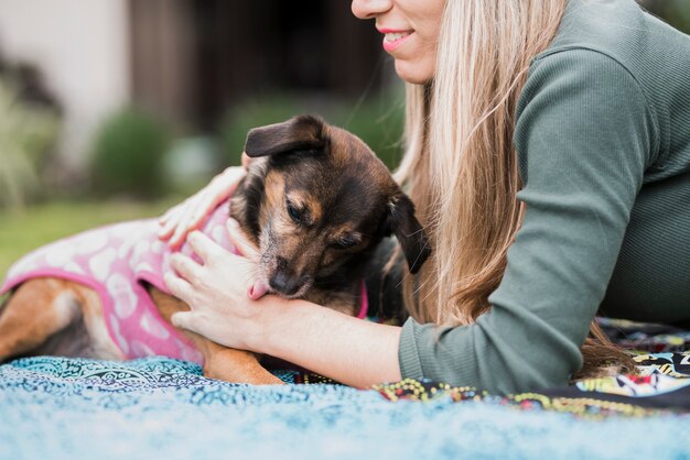 Primer plano de un perro lamiendo la mano de mujer