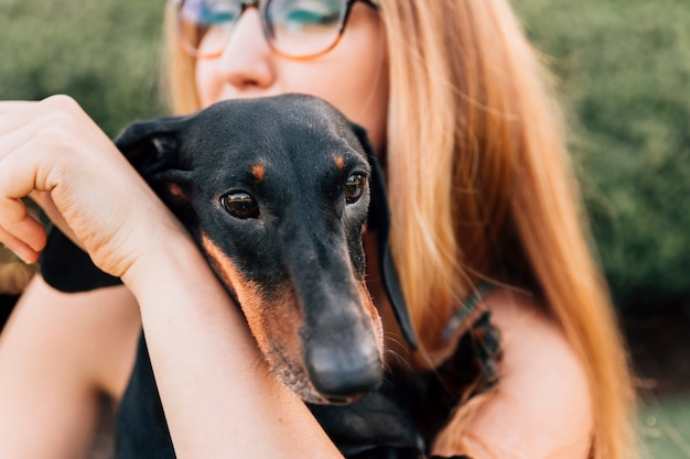 Primer plano de un perro con mujer joven