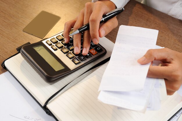 Primer plano de persona con billetes y calcularlos