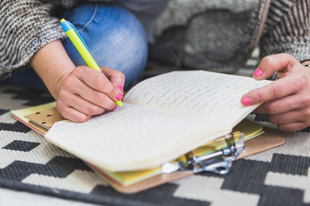 Primer plano de persona escribiendo en una libreta