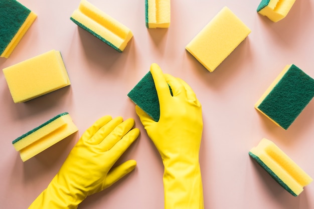 Primer plano [persona con guantes amarillos y esponjas