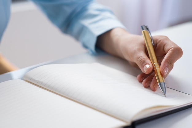 Primer plano de la persona que hace notas en el cuaderno