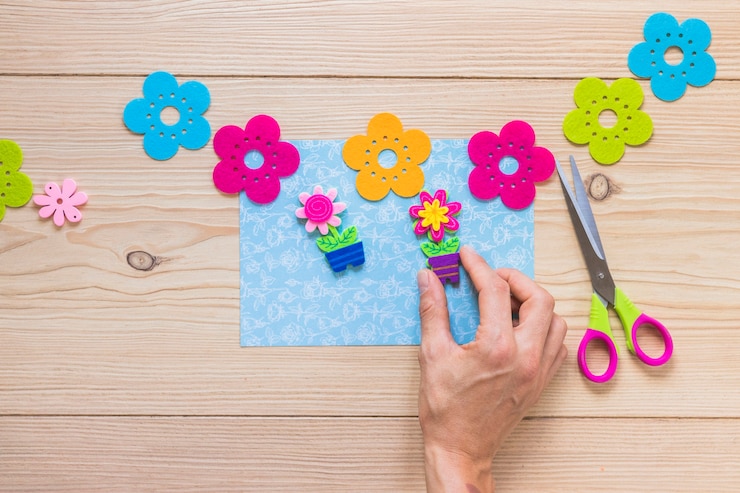 Foto gratuito primer plano de una persona que se pega parche de flores en la tarjeta azul