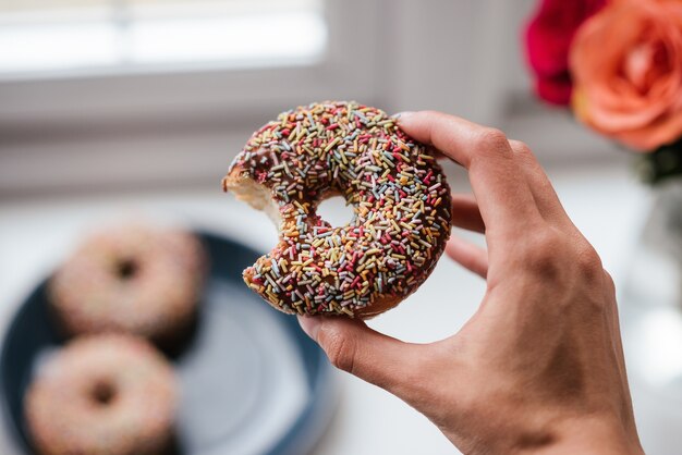 Primer plano de una persona sosteniendo una rosquilla