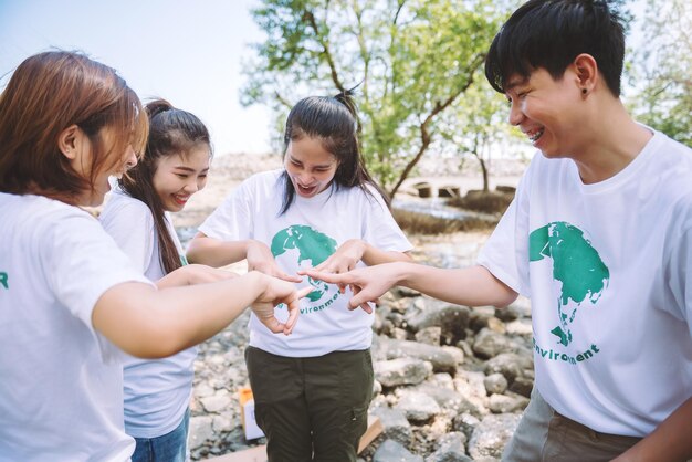 Primer plano de personas voluntarias trabajo en equipo poniendo el dedo en forma de estrellamanos juntasPila de manosUnidad y trabajo en equipo en el día mundial del medio ambiente