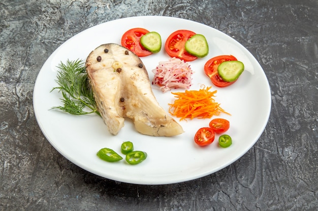 Primer plano de pescados crudos y alimentos frescos de pimienta en un plato blanco sobre la superficie del hielo con espacio libre