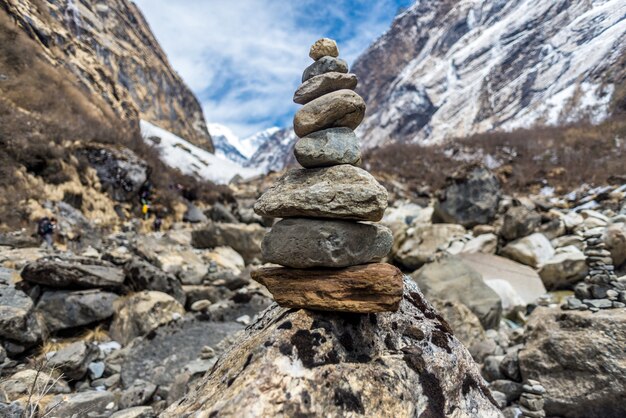 Primer plano de piedras una encima de la otra rodeadas por rocas cubiertas de nieve bajo la luz del sol