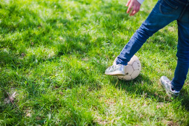 Primer plano de piernas jugando con un balón