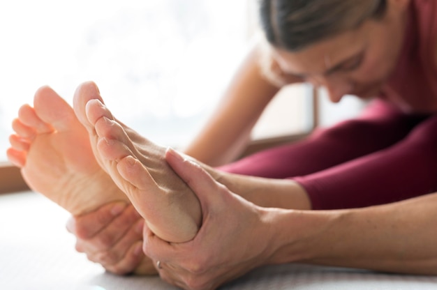 Primer plano de las piernas y las manos en una mujer fitness vista lateral