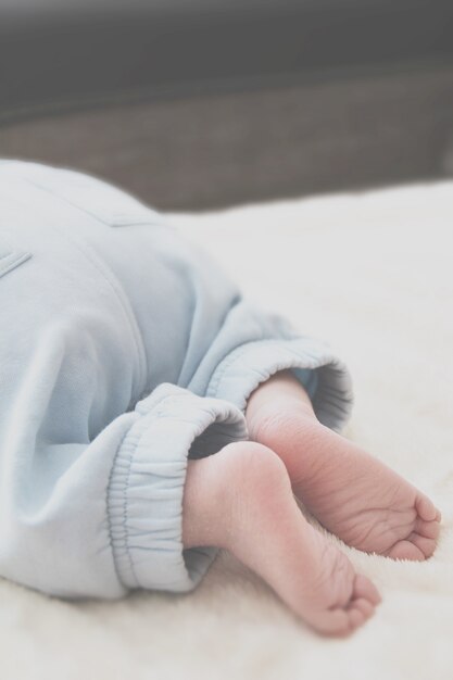Primer plano de los pies del bebé sobre una manta blanca