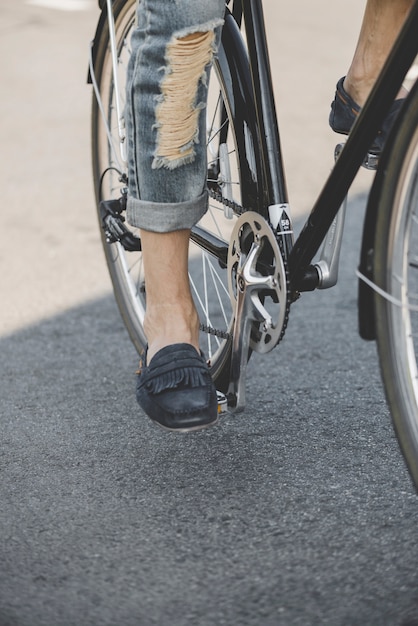 Foto gratuita primer plano de los pies del hombre en la paleta de la bicicleta