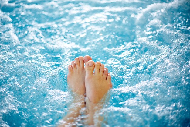 Primer plano de los pies de la mujer en el jacuzzi