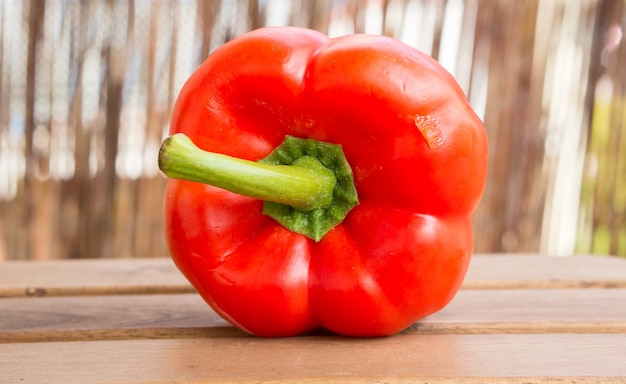 Primer plano de un pimiento rojo fresco medio cortado sobre una superficie de madera