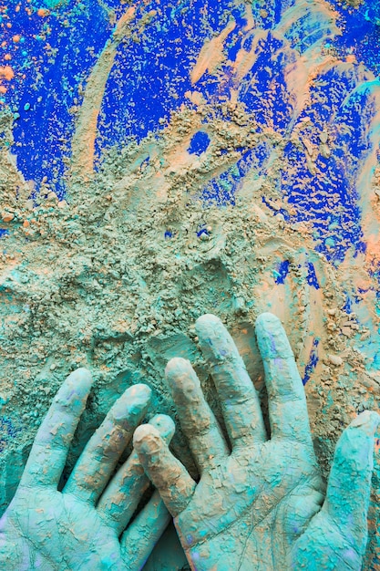 Primer plano de pintado a mano con polvo de color holi sobre fondo azul