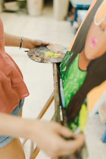 Primer plano de pintura de mujer con pintura al óleo sobre caballete