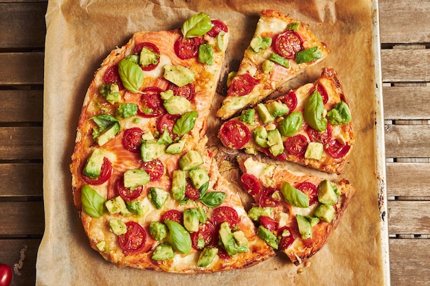 Primer plano de una pizza con verduras en la mesa de madera