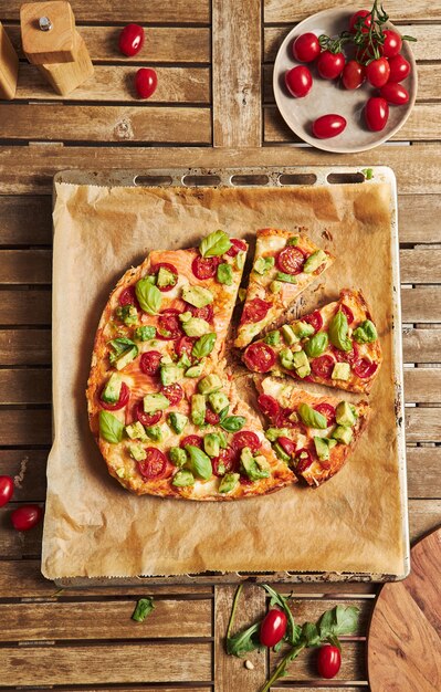 Primer plano de una pizza con verduras en la mesa de madera