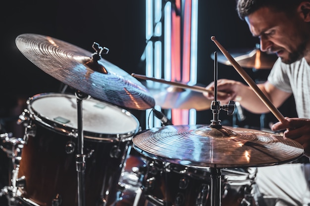 Primer plano de platillos de batería mientras el baterista juega con una hermosa iluminación sobre un fondo borroso.