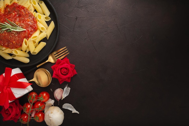 Foto gratuita primer plano de un plato de pasta, regalo, rosas y verduras-concepto día de san valentín