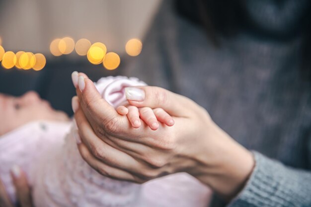 Primer plano de una pluma de una niña recién nacida en la mano de las mamás