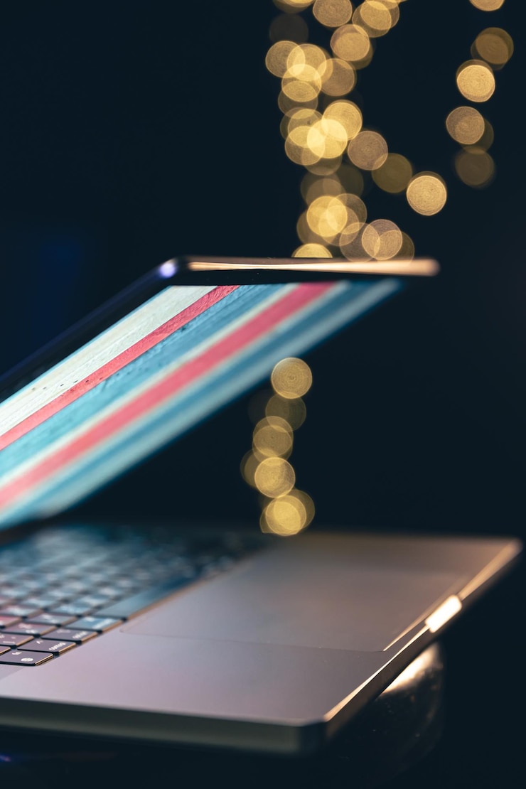 Foto gratuito primer plano de un portátil sobre un fondo oscuro con bokeh