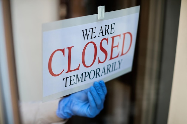 Primer plano del propietario cerrando un restaurante durante la pandemia de coronavirus