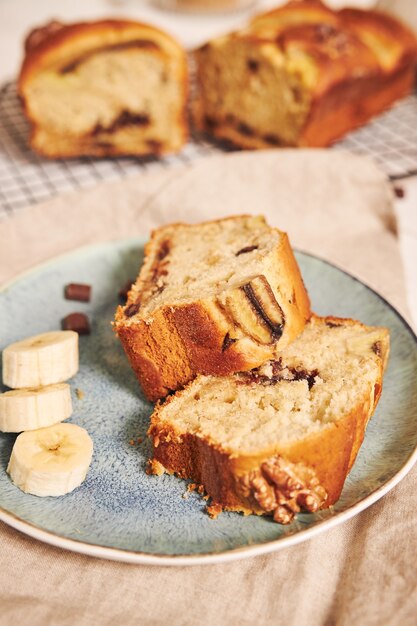 Primer plano de rebanadas de delicioso pan de plátano con trozos de chocolate y nueces en un plato