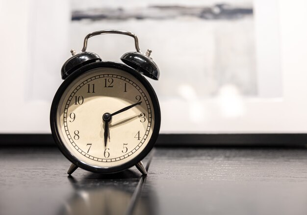 Primer plano de un reloj despertador vintage sobre un fondo borroso, copie el espacio.