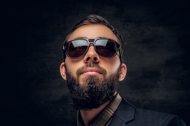 Primer plano retrato de hombre barbudo en gafas de sol aislado sobre fondo de viñeta gris.