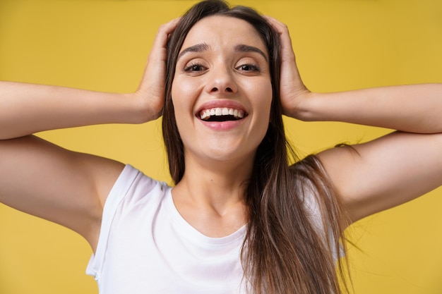 Foto gratuita primer plano retrato joven hermosa estudiante atractiva chica impactante con algo espacio de copia de fondo amarillo brillante