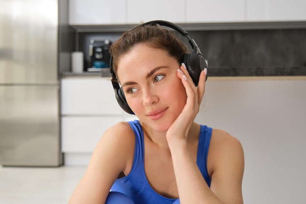 Foto gratuita primer plano retrato de una mujer fitness con sujetador deportivo escuchando música con auriculares haciendo ejercicio en