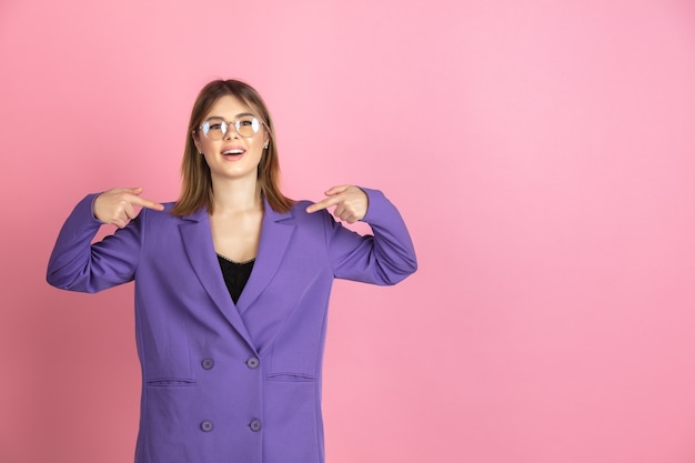 Foto gratuita primer plano retrato de mujer joven caucásica en estudio rosa, emocional y expresivo