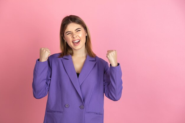 Primer plano retrato de mujer joven caucásica en rosa, emocional y expresivo