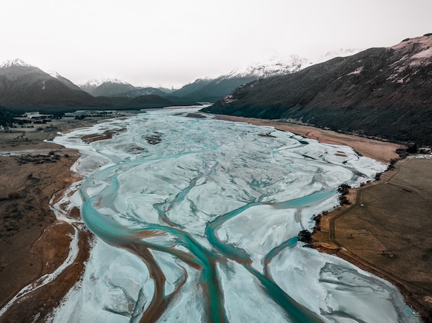 Primer plano de un río congelado en las montañas nevadas