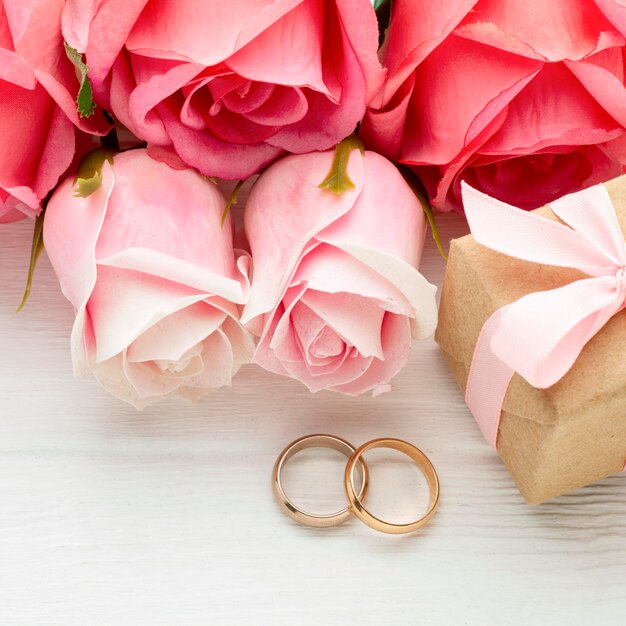 Primer plano de rosas rosadas y anillos de boda