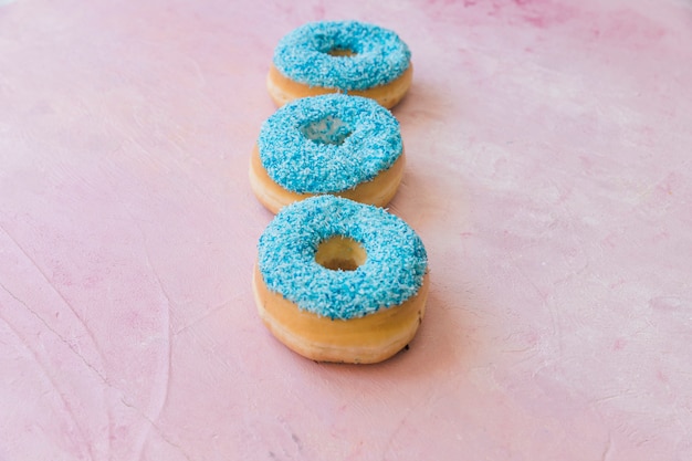 Foto gratuita primer plano de rosquillas azules frescas sobre fondo rosa