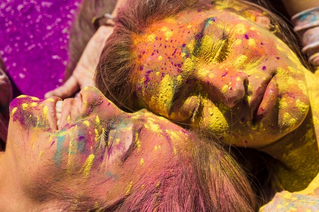 Primer plano del rostro de una mujer joven cubierto de color holi.