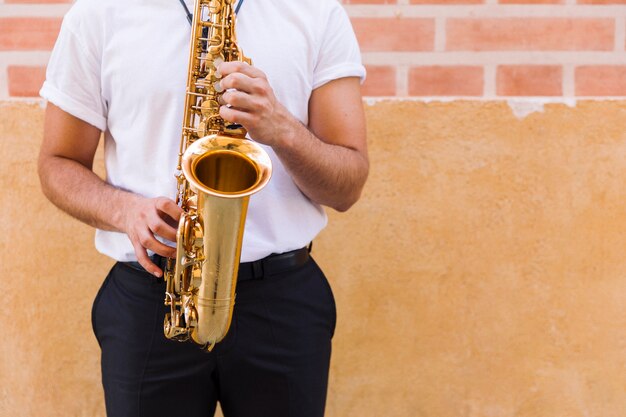 Primer plano de saxofón tocado por el hombre.