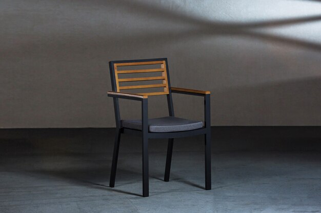 Primer plano de una sencilla silla moderna con patas metálicas en una habitación con paredes grises